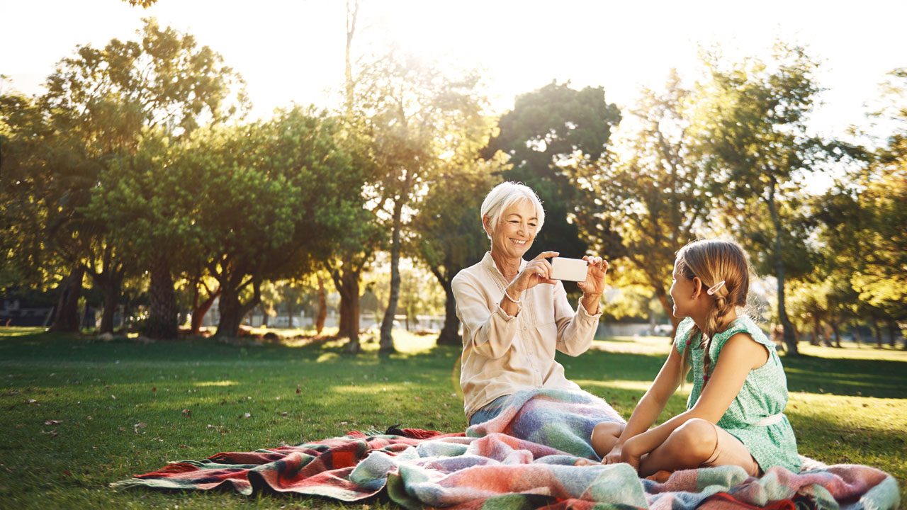 Older woman taking picture of her grand-daughter